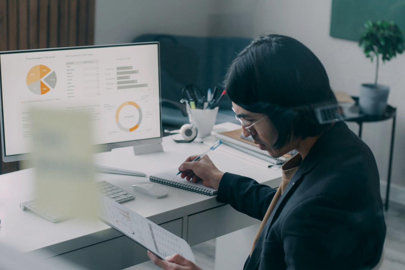 An analyst comparing printed market evidence with a restrained digital data view